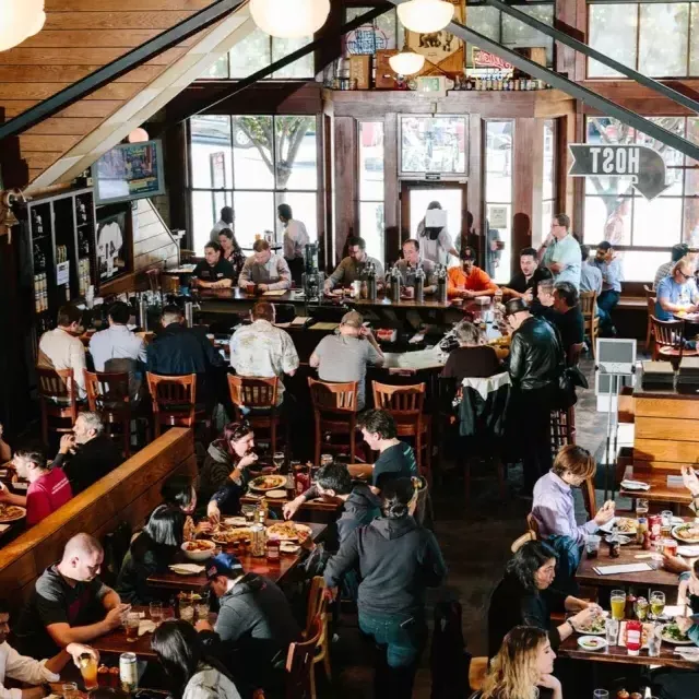 I clienti mangiano e bevono all'interno della 21st Amendment Brewery di San Francisco.